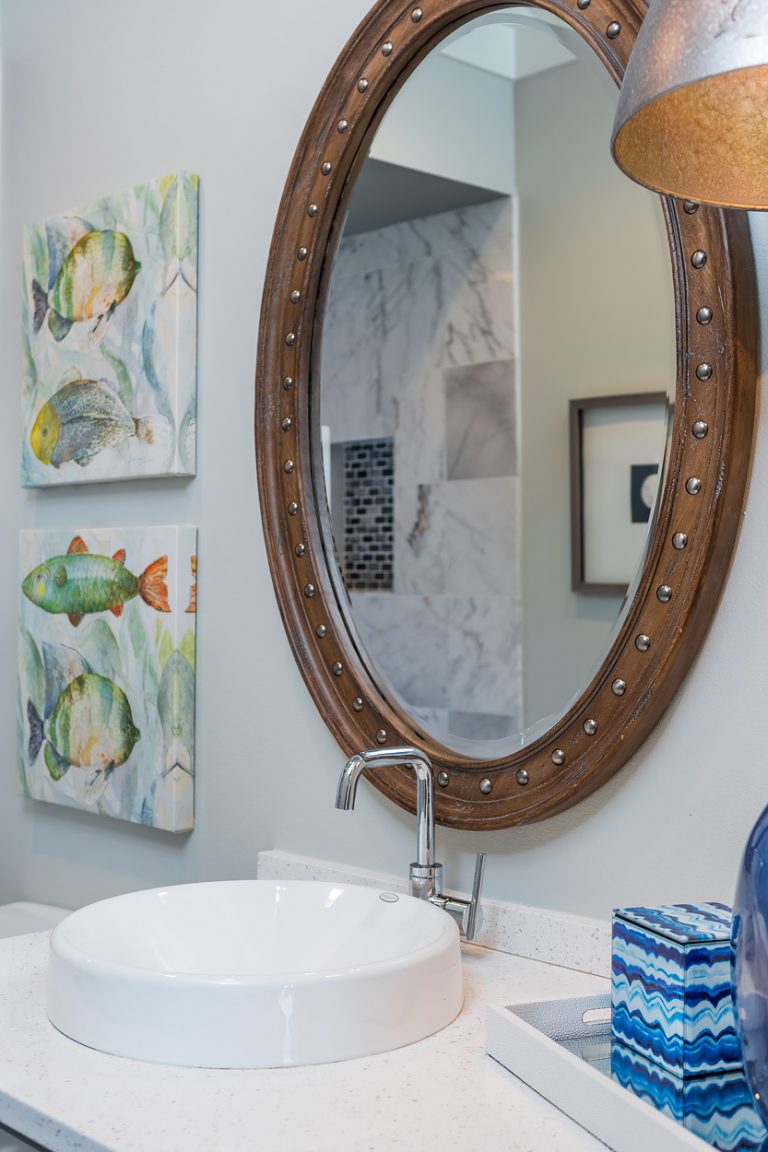 Budget bath with nautical theme, porthole mirror, and colorful fish accents