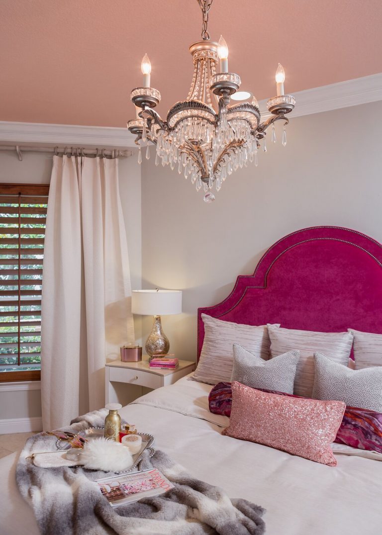 bedroom with hot pink upholstered headboard crystal cahndelier