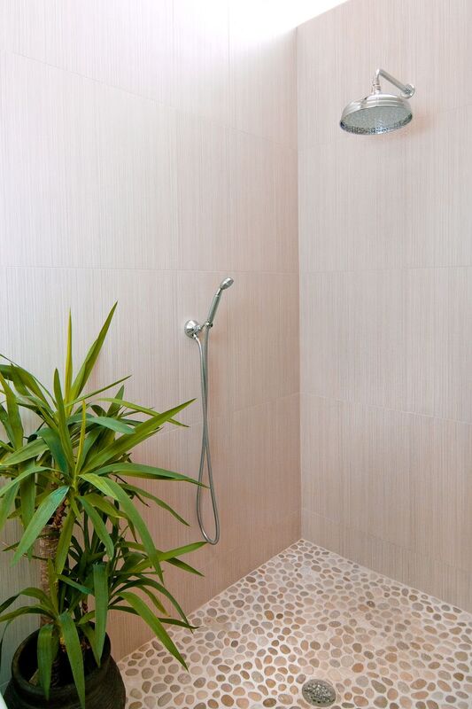 open shower master bath with walk in shower and pebble flooring