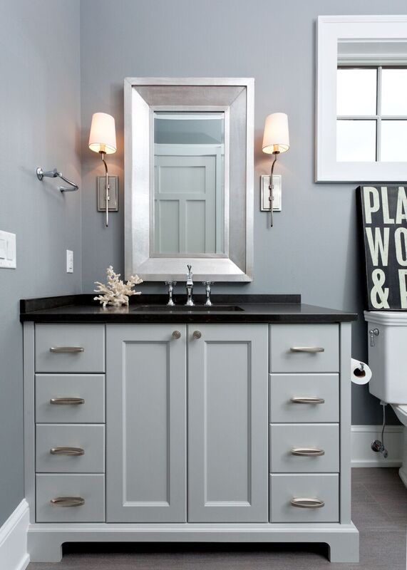 bathroom with grey cabinets and walls stainless sconces and black countertop