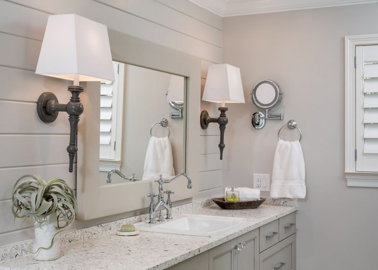 Coastal bath, countertop and sink with polished nickel faucet and wooden oval mirror with silve studs crystal cabinet pulls, large mirror and beautiful sconces in Pensacola Florida
