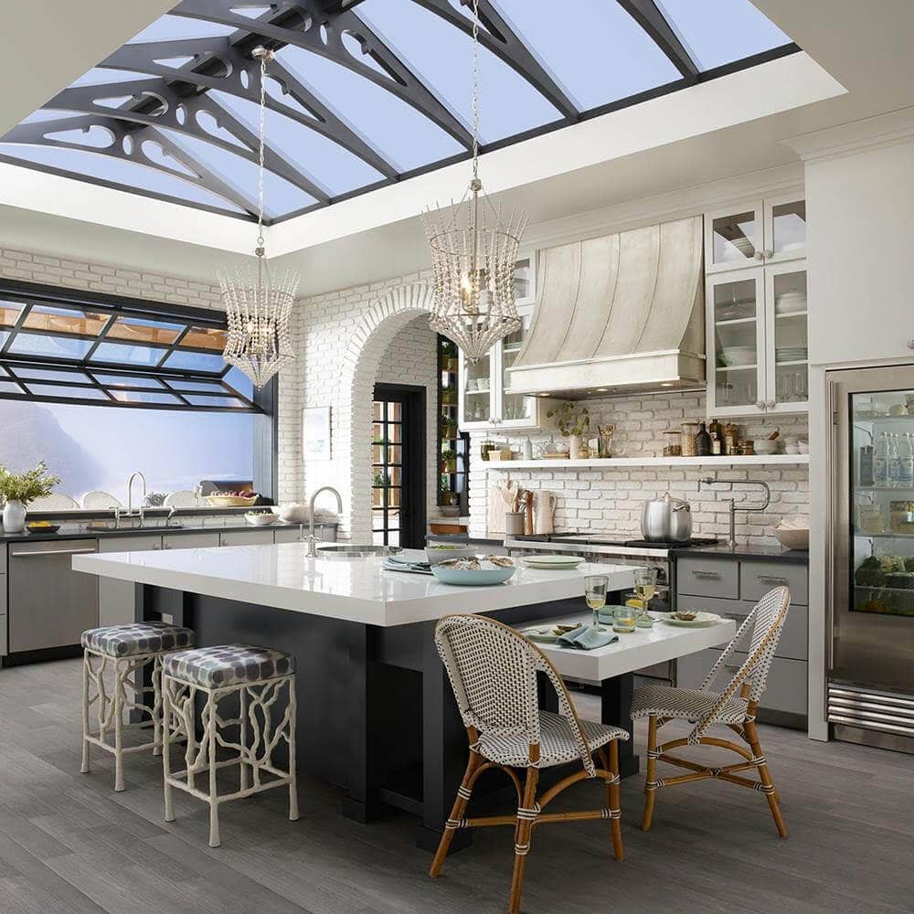 garden kitchen with vaulted ceiling kitchen island beautiful wood flooring white beaded hanging lights, garage style window, custom counterstools,