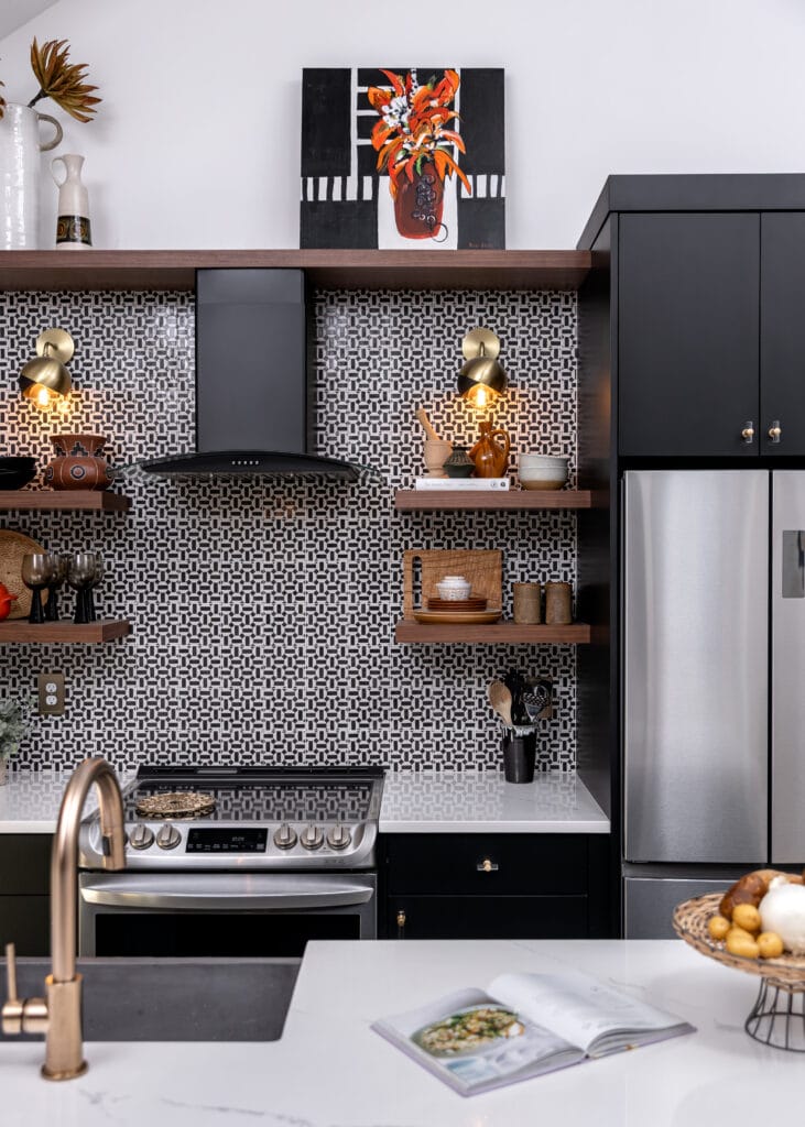 Tiny house kitchen with a black and white patterned tile backsplash. Contemporary and eclectic design. Open shelving, black cabinets, brass fixtures, and quartz countertops.